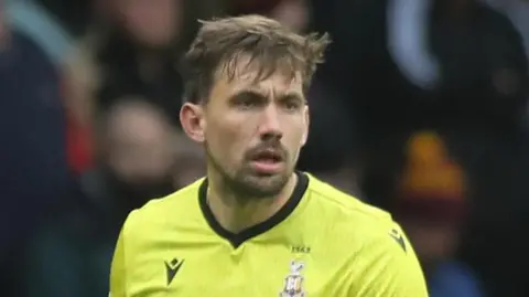 Sam Walker in a yellow Bradford City goalkeeper jersey during a match