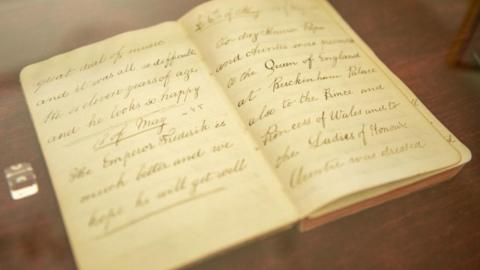 An open book containing old fashioned-looking handwriting