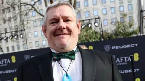 Getty Images John Davidson attends the EE BAFTA Film Awards 2026 at The Royal Festival Hall on February 22, 2026 in London, England