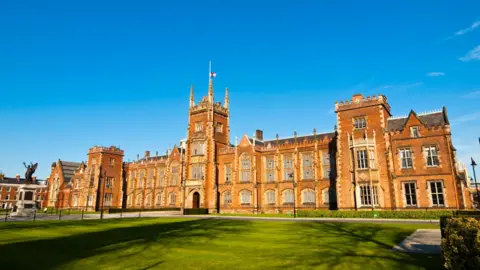 Getty Images The exterior of Queen's University Belfast's red brick Lanyon Building, with a blue sky in the background and a green lawn at the front.