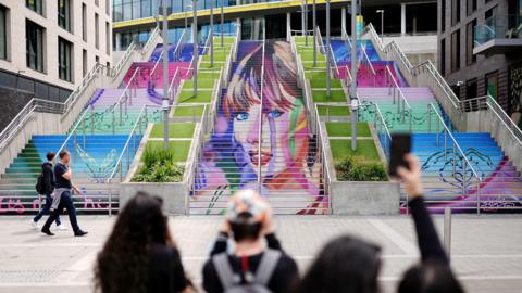 Staircase of multi-coloured artwork featuring Taylor Swift at Wembley