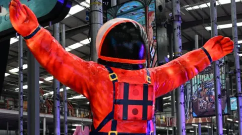 Visit Blackpool A light display featuring a large orange coloured, illuminated figure in a spacesuit.