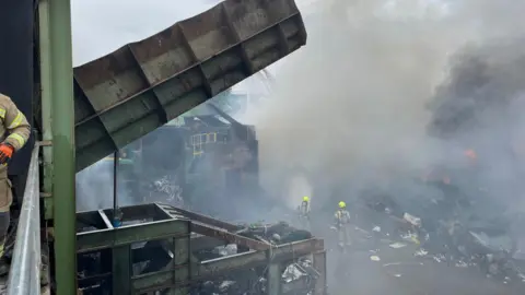 Suffolk Fire and Rescue Service Firefighters at the scene of a recycling centre fire after it has been extinguished