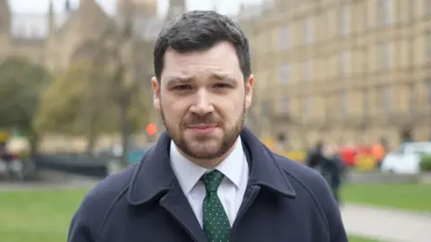 Henry Zeffman outside parliament wearing a suit