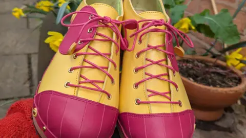 Jackie Leggett the clogs are bright pink and yellow with nails around the edge 
