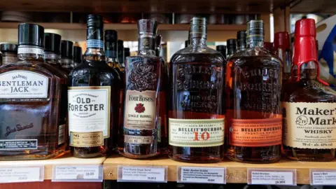 Getty Images Various types of American bourbon whiskeys are displayed on the shelf of a whiskey store on March 13, 2025 in Berlin, Germany. 