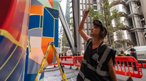 London Mural Festival Anna Ovni painting her mural at the Leadenhall Building in the City of London