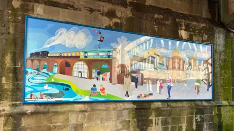 A large rectangular mural featuring images of local landmarks and buildings.
