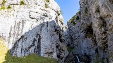 Getty A limestone gorge with twin rock faces split by a ravine. 