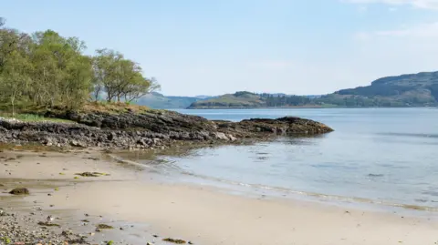 Sothebys International Realty A sandy beach on Shuna nestles behind a rocky outcrop.