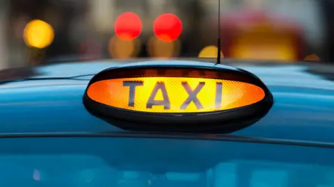 A zoomed in shot of a sign on a black taxi cab