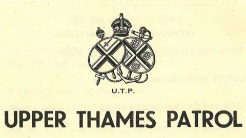 Royal Berkshire Archives The logo of the Upper Thames Patrol on a cream background with the words and a symbol depicting two shields and a crown appear in black type.