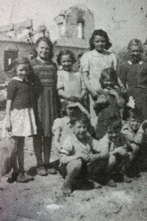 Gloria Bullen A black and white photograph of ten children grouped for the photo in front of the schloss