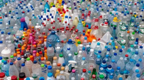 Richard Lord Hundreds of different types of plastic bottle lined up as part of a display