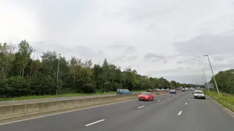 Google Section of road on A1 southbound near Metrocentre. Trees are on the side. Several cars are on the road driving. 