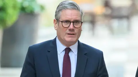 British Prime Minister Keir Starmer visits the Economic Crime Team at the City of London Police HQ wearing a suit