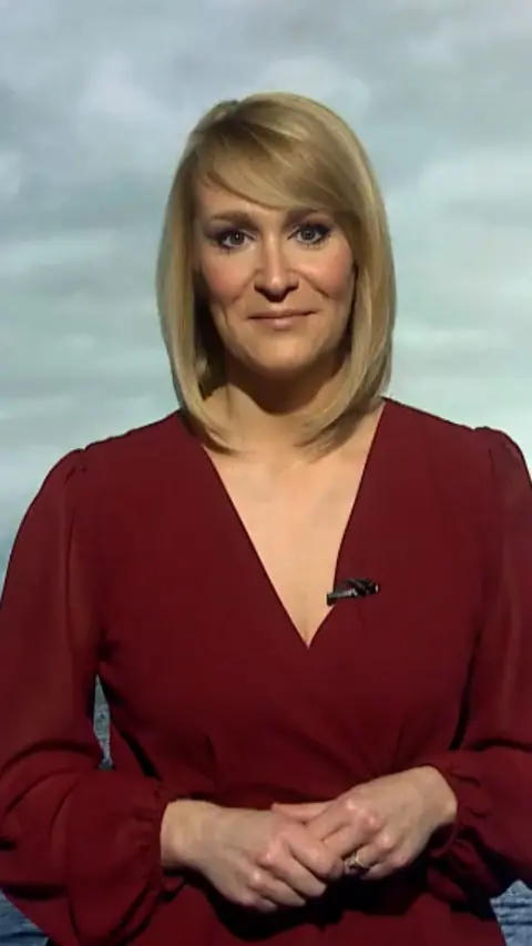 Weather presenter Kirsteen MacDonald looking and smiling at the camera. She is wearing a red dress.
