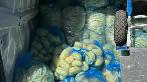 Stratford Police Potatoes are visible in blue bags in the foreground and at least 10 bags are in the background. 