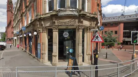 The outside of Boston Tea Party, with the sign visible on the door and a white BTP sticker on the window.