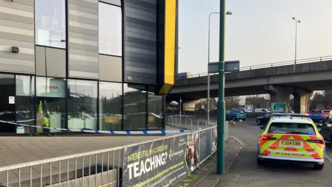 Police vehicle near a cordon at a school