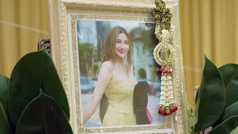 A photo of Nahathai in front of a bouquet at her funeral