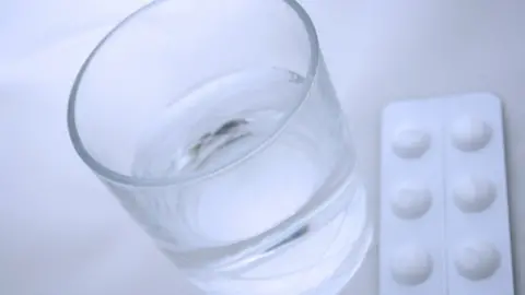  A packet of painkillers and a glass of water