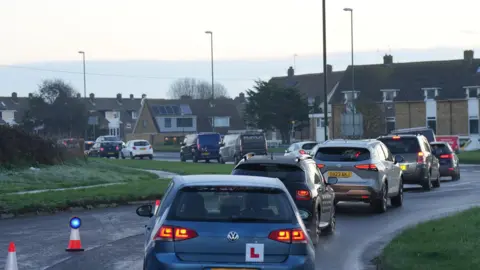 Eddie Mitchell A queue of cars lined up at the scene of the crash at Saltings roundabout