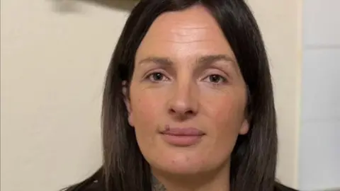 A women with brown hair looking directly at the camera