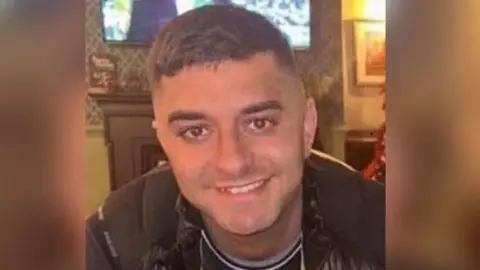 Supplied Jordan Hogg. He is smiling as he looks into the camera. He has short dark hair and is wearing a grey-and-navy top with a black body warmer.