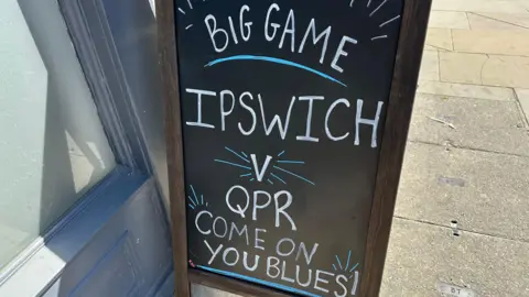Ben Parker/BBC A sign outside a venue that reads "Big Game, Ipswich vs QPR, Come on you Blues".