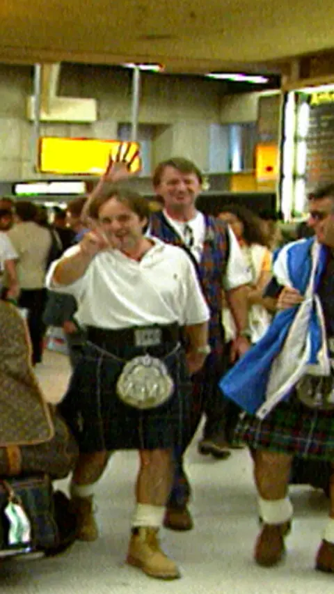 Men in kilts in airport.