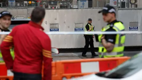 Getty Images Officers behind a police cordon after the attack on the Park Inn hotel in Glasgow