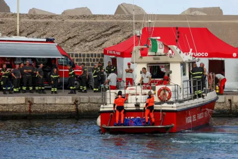 Reuters Rescue personnel transport a body bag after a luxury yacht, which was carrying British entrepreneur Mike Lynch, sank off the coast of Porticello, near the Sicilian city of Palermo, Italy, August 21, 2024. 