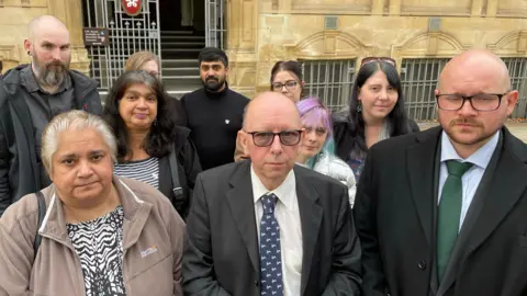 A group of people gathered outside of Leicester Town Hall