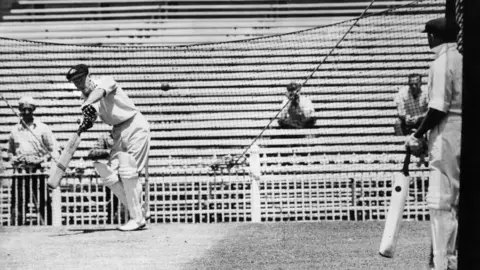 Getty Images Australian cricketer Don Bradman (1908 - 2001) gives a batting lesson to Bill Brown before the fifth Test against India. (Photo by Keystone/Getty Images)
