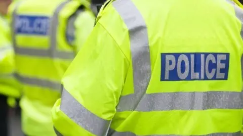 Generic photo of the back of police officers, with high-vis jackets.