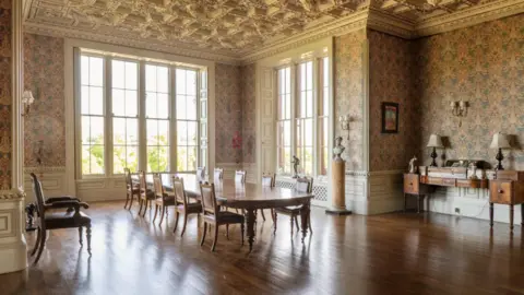 Knight Frank A dining room with a grand table and large windows and a panelled floor