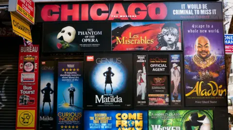 Getty Images A collection of theatre posters on a wall in London, for various productions including Les Miserables, The Phantom of the Opera, Matilda, Wicked, Thriller, The Curious Incident of the Dog in the Night-Time and Aladdin.