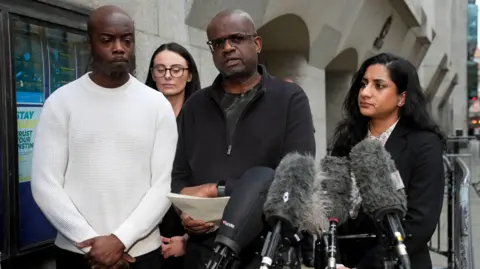 PA Michael Andam (centre), the father of Elianne Andam is accompanied by family members as he speaks to the media outside the Old Bailey