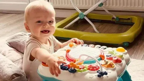 Family handout A baby plays with his toys in the sunny room.