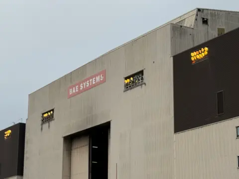 Smoke damage to the outside of the building, which is made of metal. A large door is open.