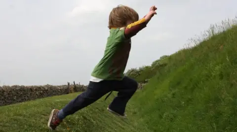 A young boy jumping on grass