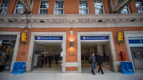 Getty Images Two people in the brick archway of the entrance to Waterloo East station