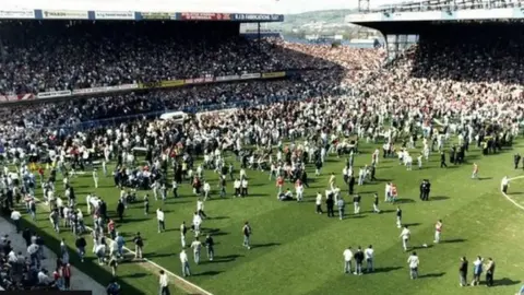 Fans on the pitch as they escape the crush at Hillsborough