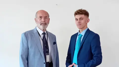 Reform UK Two men in jackets and ties. The one on the right wears a turquoise tie