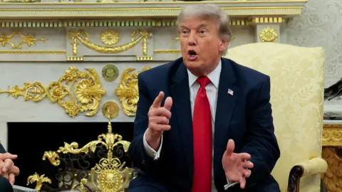 US president Donald Trump speaks with reporters in the Oval Office of the White House