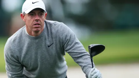 Rory McIlroy looks for his ball after hitting a tee shot