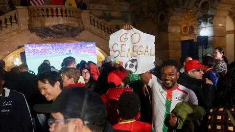 Bloomberg via Getty Images An attendee holds a "Go Senegal" sign during a watch party for the Africa Cup of Nations (AFCON) final match with Zohran Mamdani, mayor of New York,