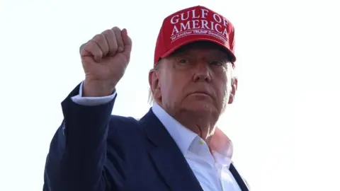 US President Donald Trump holds a fist in the air