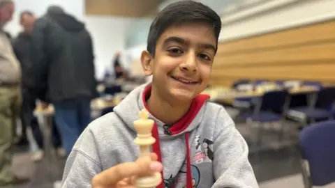 Rayyan, 14, prepares to face a chess grandmaster at an event in Bristol.